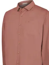 Camisa celeste de manga larga con cuello camisero, cierre con botones de madera y bolsillo en el pecho.