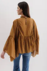 Camisa color marrón con cuello mao, mangas largas abullonadas y detalle de volados en el frente.