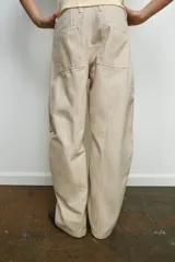 Pantalón cargo color beige de la colección Zara Woman, con tiro medio, cintura con trabillas, bolsillos delanteros y de plastrón con solapa en la pierna. Cierre frontal con cremallera y botón.