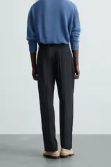 Pantalón de traje para hombre de corte regular fit, confeccionado en una mezcla de cáñamo y lana de origen italiano. Presenta bolsillos frontales, bolsillos traseros de vivo y cierre frontal con cremallera y botón.