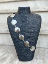 Cinto dorado de metal con eslabones y monedas circulares texturadas.