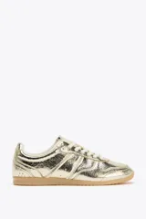 Zapatillas deportivas doradas con efecto metalizado y cierre con cordones.
