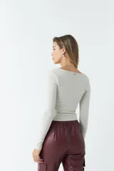 Top de manga larga color marrón con escote cuadrado, ceñido al cuerpo y diseño elástico que imita la silueta de un corset.
