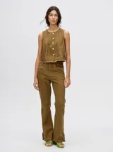 Pantalón de jean azul de tiro alto y corte oxford con apliques metálicos en bolsillos y laterales.