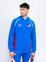 Canguro hoodie azul con capucha, cordones ajustables, bolsillo canguro y detalles en blanco y rojo en los costados y mangas. Incluye el logo de Umbro y el escudo del Club Nacional de Football en el pecho.