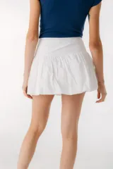 Minifalda blanca con volados y cintura alta.