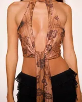 Top color marrón con estampado floral, estilo pañuelo con cuello halter y espalda descubierta con detalle de avío artesanal.