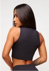 Top deportivo blanco de corte cropped, con cuello alto y logo estampado en el frente.