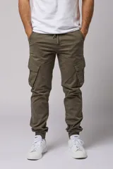 Pantalón cargo color beige de gabardina, con corte ajustado, bolsillos laterales con fuelle y puños elásticos en los tobillos.