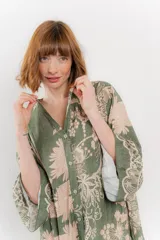 Vestido largo azul con estampado floral en tonos beige, confeccionado en viscosa. Presenta escote en V, botonadura completa en el frente y mangas largas con volados.