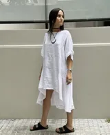 Vestido blanco de lino con corte asimétrico, más corto adelante que atrás.