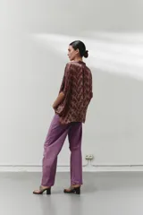 Blusa marrón con estampado abstracto, cuello camisero y botones en la parte delantera.