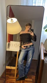 Conjunto de top y pantalón de encaje negro. El top es de escote bardot y mangas largas acampanadas. El pantalón es de corte palazzo.