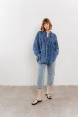 Camisa oversize blanca de algodón con pliegues frontales.