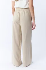 Pantalón beige de corte palazzo con cintura elastizada y cordón ajustable.