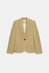 Blazer color beige de corte clásico, con cuello solapa, manga larga, bolsillos con solapa en delantero y cierre frontal con botón.