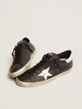 Zapatillas Golden Goose modelo Super-Star, color negro con estrella lateral blanca y refuerzo del talón blanco.
