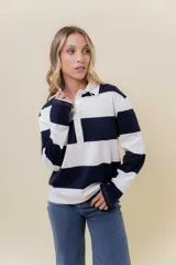 Sweater de manga larga con diseño de rayas anchas horizontales en azul marino y blanco. Posee cuello polo con cartera de botones y calce relajado.