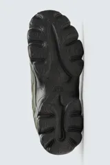 Zapatillas deportivas color crema con cordones, suela gruesa con diseño irregular y detalles en gris.