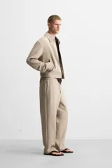Pantalón negro de corte recto con cintura elástica, bolsillos laterales y un bolsillo trasero de ojal.
