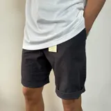 Bermuda color beige de gabardina, con bolsillos laterales y traseros.