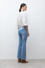 Jean de mezclilla azul medio, corte oxford o bota ancha, tiro medio/alto, con costura central marcada en el frente de ambas piernas.