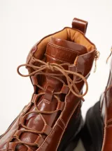 Bota negra de cuero con suela de goma, diseñada para un estilo urbano y práctico, con cierre lateral para facilitar el calzado.
