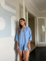 Vestido corto blanco con escote en V, mangas 3/4 con detalle de calado y volados en el ruedo. Cierre frontal con botones.