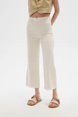 Pantalón jean blanco, recto y de calce alto con terminación desflecada.