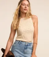 Musculosa de poliéster color crema con cuello halter y superficie texturizada.