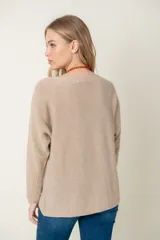 Sweater de lana color beige, de corte holgado y mangas largas.
