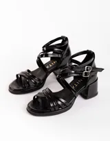 Sandalias negras de charol con tiras cruzadas y hebilla al tobillo. Tacón cuadrado. Marca Anita.