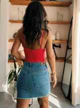 Minifalda de jean azul con bolsillos traseros y ruedo desflecado.