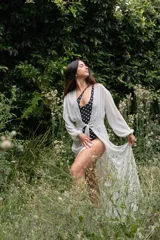 Túnica blanca traslúcida de gasa con mangas largas y lazo en la cintura.