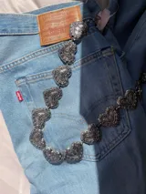 Cadena plateada para cintura con eslabones metálicos con forma de corazón con grabados.