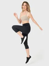 Calza capri deportiva negra de tiro alto con logo estampado en la cintura.
