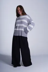 Sweater Bremer con cuello redondo y mangas largas ligeramente amplias. Diseño a rayas horizontales en color crudo y negro.