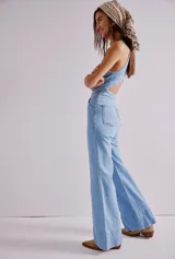 Mono largo de denim celeste, con corte entallado, escote en V, cierre frontal con botones y bolsillos laterales.