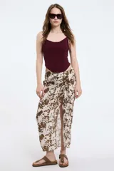 Pollera midi con estampado animal print color marrón y blanco, con abertura lateral y detalle de frunce con lazo en la cintura.