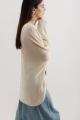 Sweater color crema de viscosa, poliéster, elastano y lurex, de corte holgado y mangas largas.