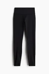 Calzas deportivas negras de tejido funcional DryMove™ que ayuda a absorber el sudor. Diseño con cintura ancha de tiro alto y bolsillo oculto en la parte trasera.