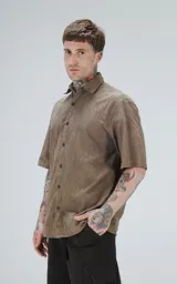 Camisa manga corta color verde militar con textura y cuello clásico.