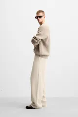 Pantalón largo color beige confeccionado en pana de algodón, de corte wide fit, con bolsillos frontales y traseros.