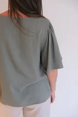 Blusa verde con escote en V y mangas cortas con volados.