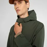 Parka ligera color verde con capucha, diseño moderno y cortes amplios.
