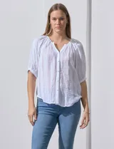 Blusa blanca de algodón marca Zac & Rachel, con cuello a la base, escote en V, abertura central con botones y sisa con aplique calado.