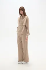 Pantalón deportivo negro de corte holgado, con cintura elástica, bolsillos laterales y botones a presión en las costuras laterales de las piernas.