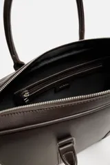 Maletín negro con textura grabada, cierre de cremallera, bolsillo interior para dispositivos electrónicos de hasta 13 pulgadas, bolsillo frontal con cremallera, doble asa de mano y asa de hombro ajustable y extraíble.