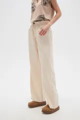 Pantalón de jean color beige, de tiro alto, corte palazzo y estilo paper bag.