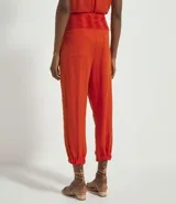 Pantalón jogger color naranja, con cintura alta elástica y terminación ajustada con elástico en los tobillos.